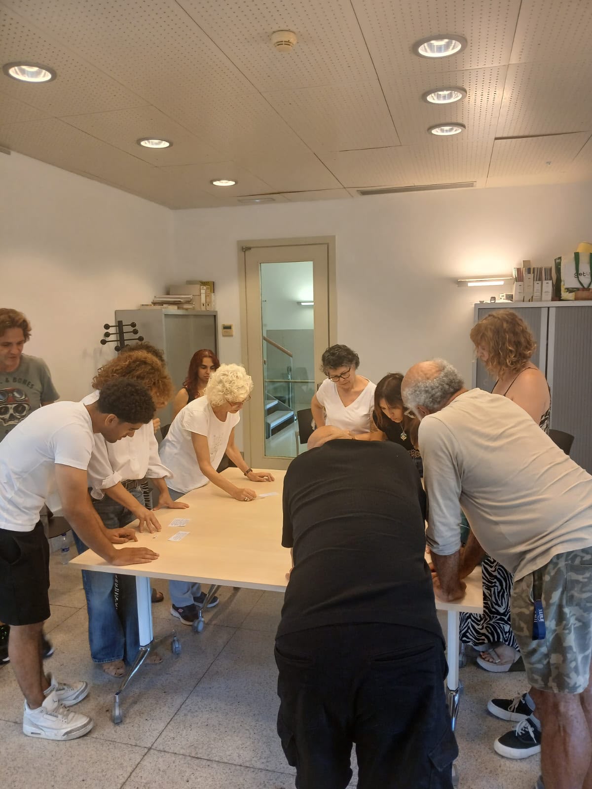 Grup d'agents cívics dels districtes de Sant Martí i l'Eixample treballant al voltant d'una taula durant una dinàmica participativa de mediació