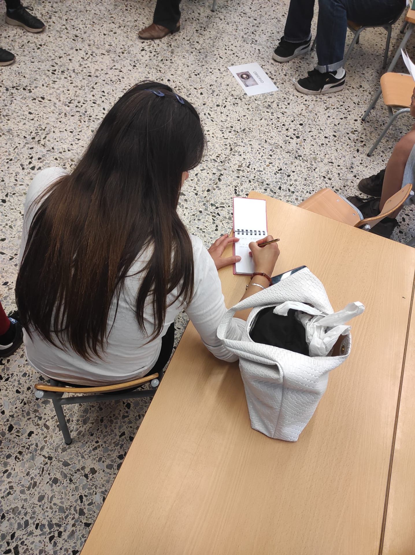 Alumna de l'Escola Montseny escrivint reflexions en una llibreta durant el Projecte Bústia d'Aula