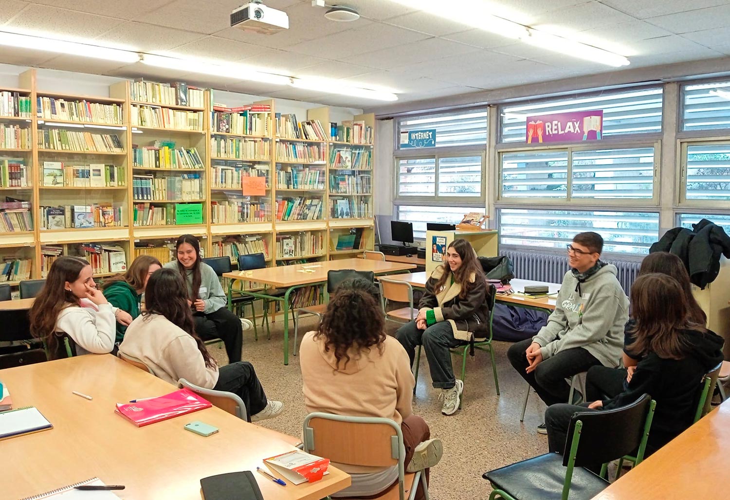 Equip d'alumnes mediadors en cercle a la biblioteca de l'escola durant una sessió de formació en mediació entre iguals