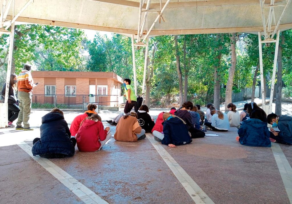 Alumnat de primària fent una dinàmica de cohesió de grup al pati de l'escola