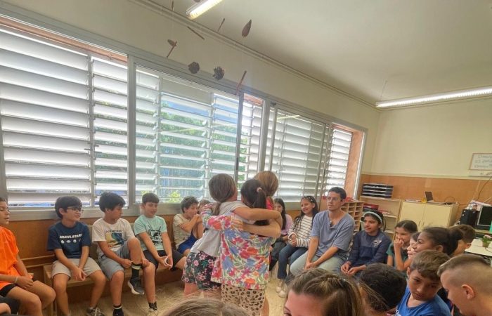 Alumnes de l'Escola Bogatell durant un Cercle de Confiança amb una abraçada espontània entre companys