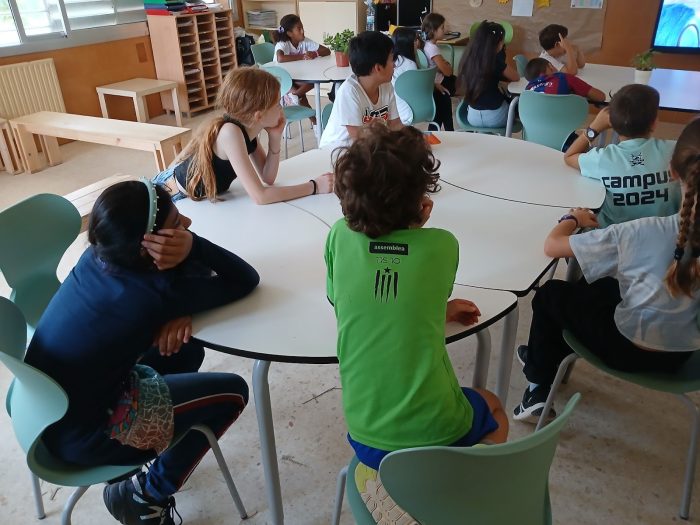 Grup de cinquè de primària de l'Escola Bogatell treballant en cercle al voltant d'una taula