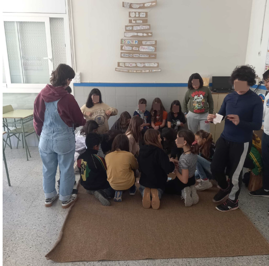 Grup d'infants en cercle a l'aula compartint emocions dins d'un espai de diàleg escolar