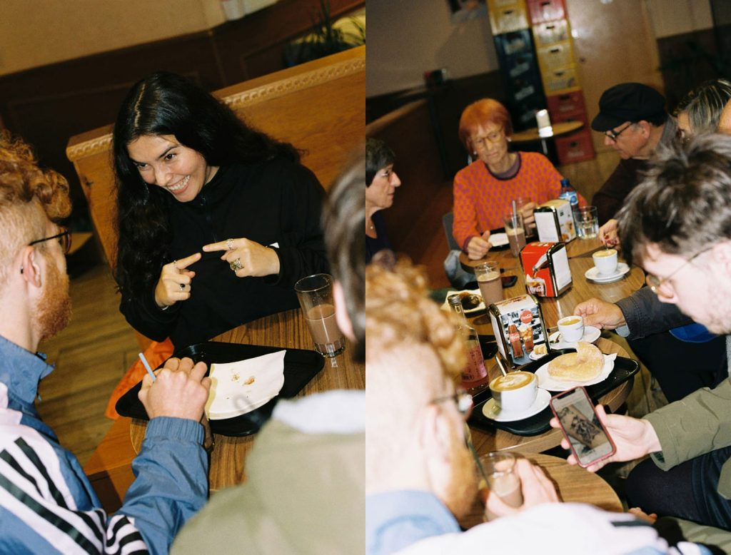 Joves i persones grans dialogant en un cafè durant una sessió informal del projecte Sapere Aude
