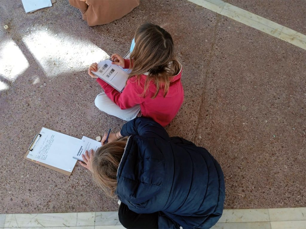 Alumna de cinquè de primària acompanyant una infant de segon en una activitat de mentoratge i coaching educatiu