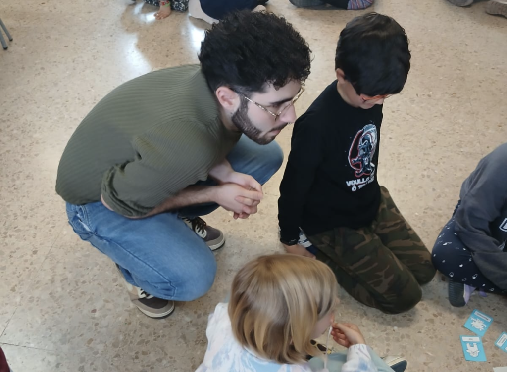 Educador acompanyant infants en una dinàmica vivencial sobre microagressions a l'Escola Els Pins