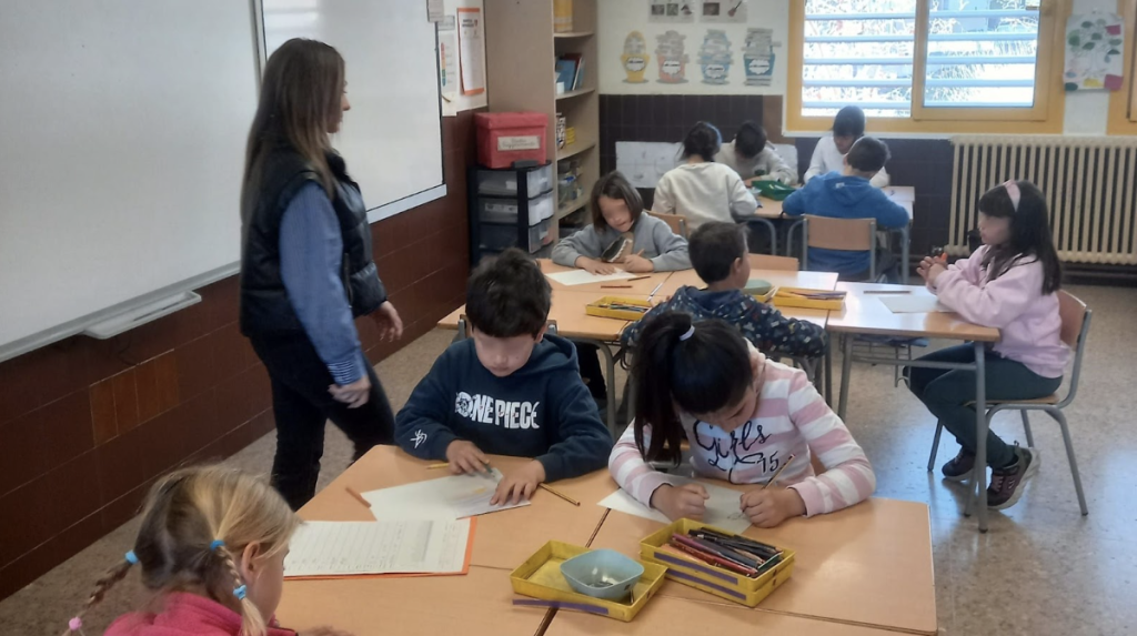Mestra acompanyant l'alumnat en una activitat d'aula del projecte APS sobre microagressions