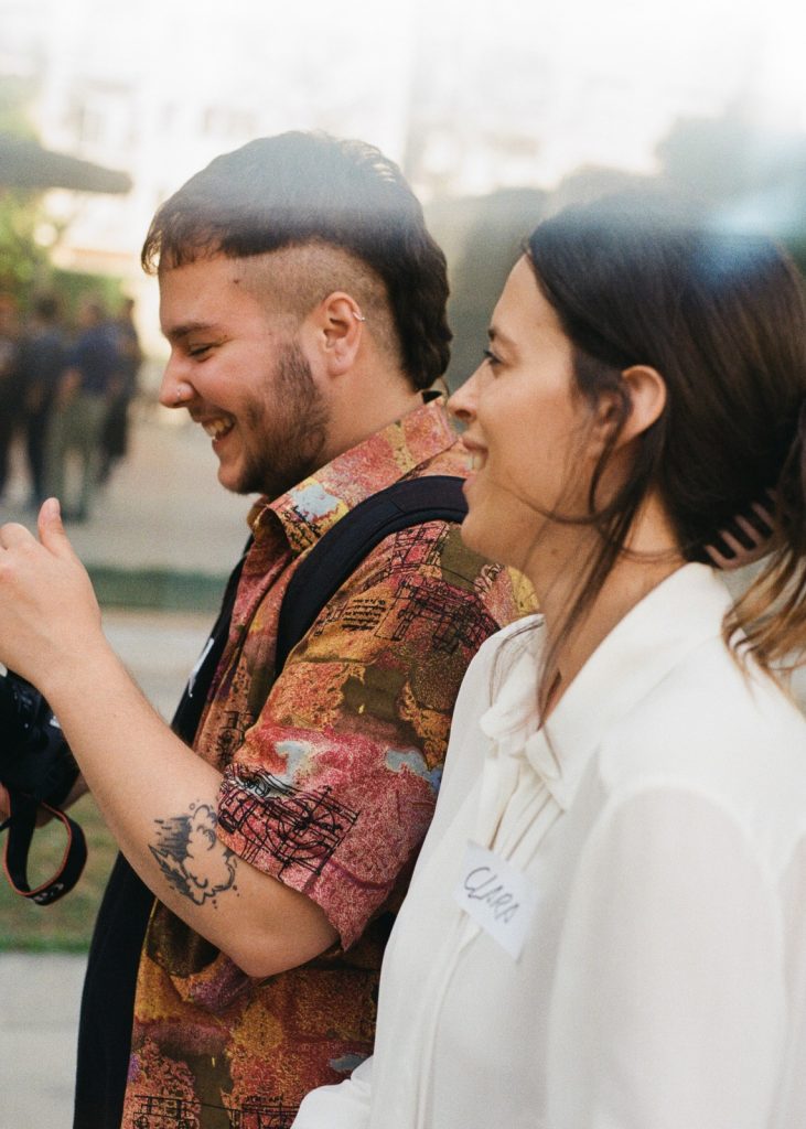 Un jove i una jove participants compartint un moment de complicitat durant una sessió de fotografia