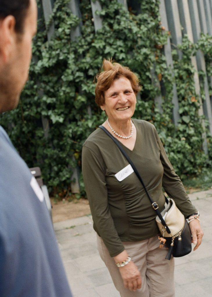 Participant gran somrient durant una conversa intergeneracional a l'espai comunitari