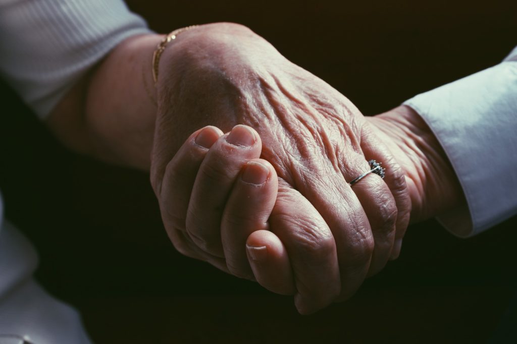 Mans d'una persona gran sostingudes amb afecte durant una sessió del projecte Mirades intergeneracionals